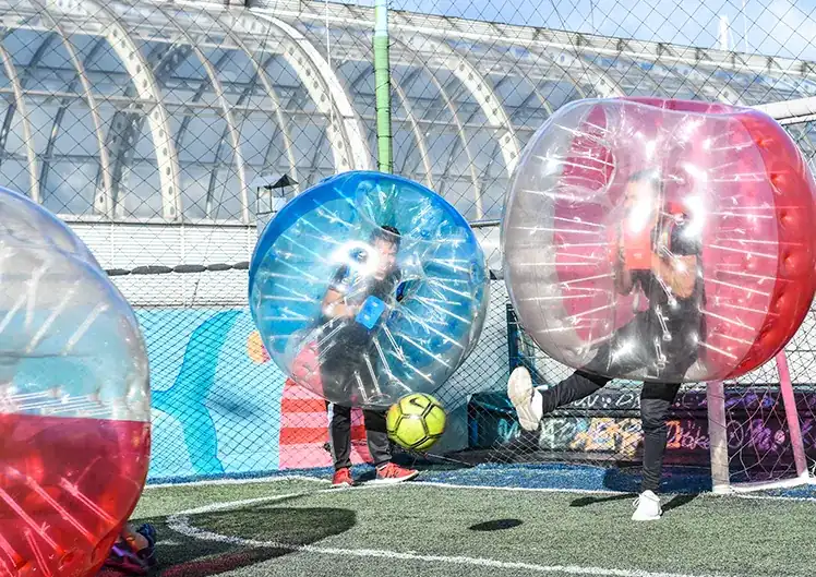 Jugador pasando el balón a su compañero dentro de una burbuja gigante.