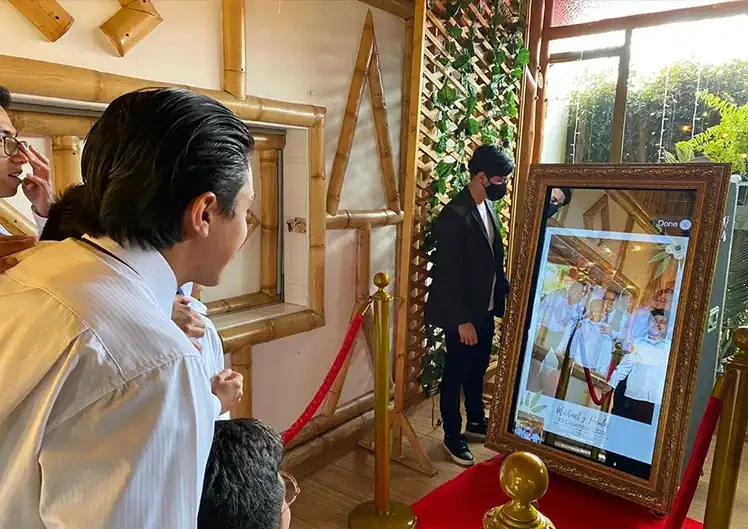 Invitados interactuando con la pantalla táctil del Espejo Mágico.