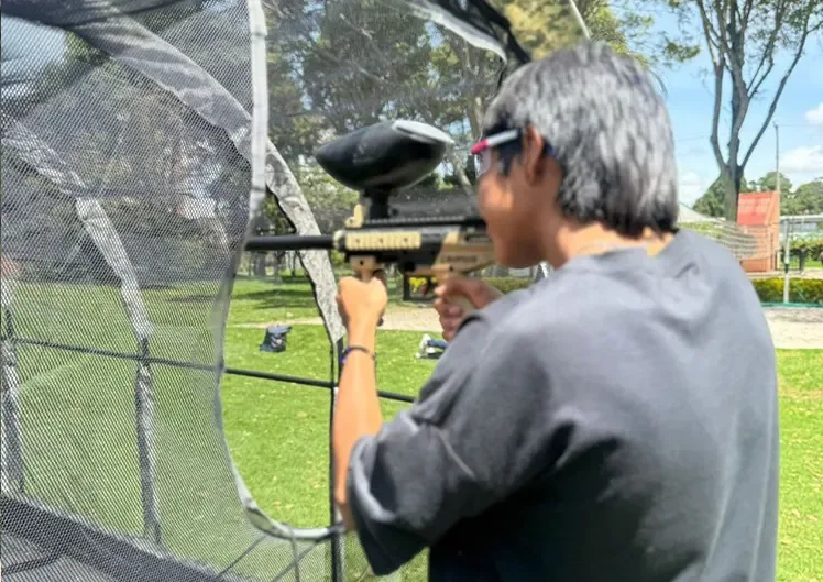 Niño participando en el juego de tiro al blanco del túnel de paintball.